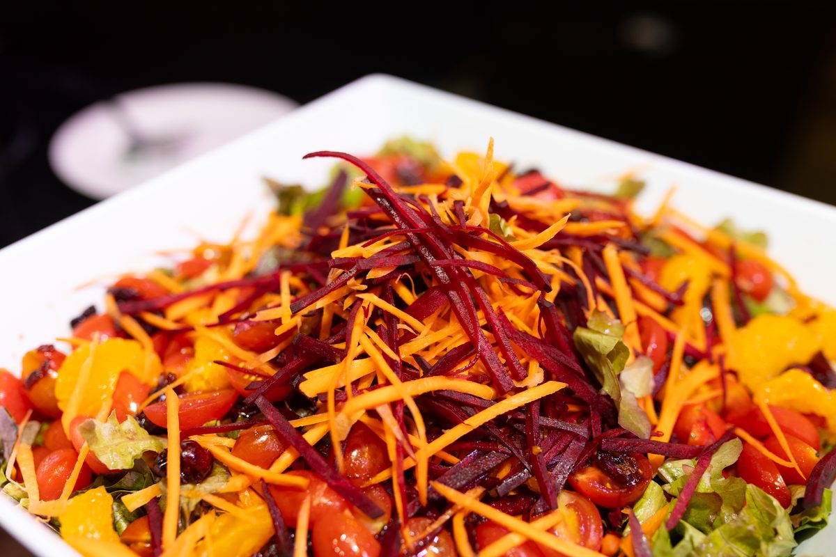 Serve It Up salad plated in a branded wooden bowl