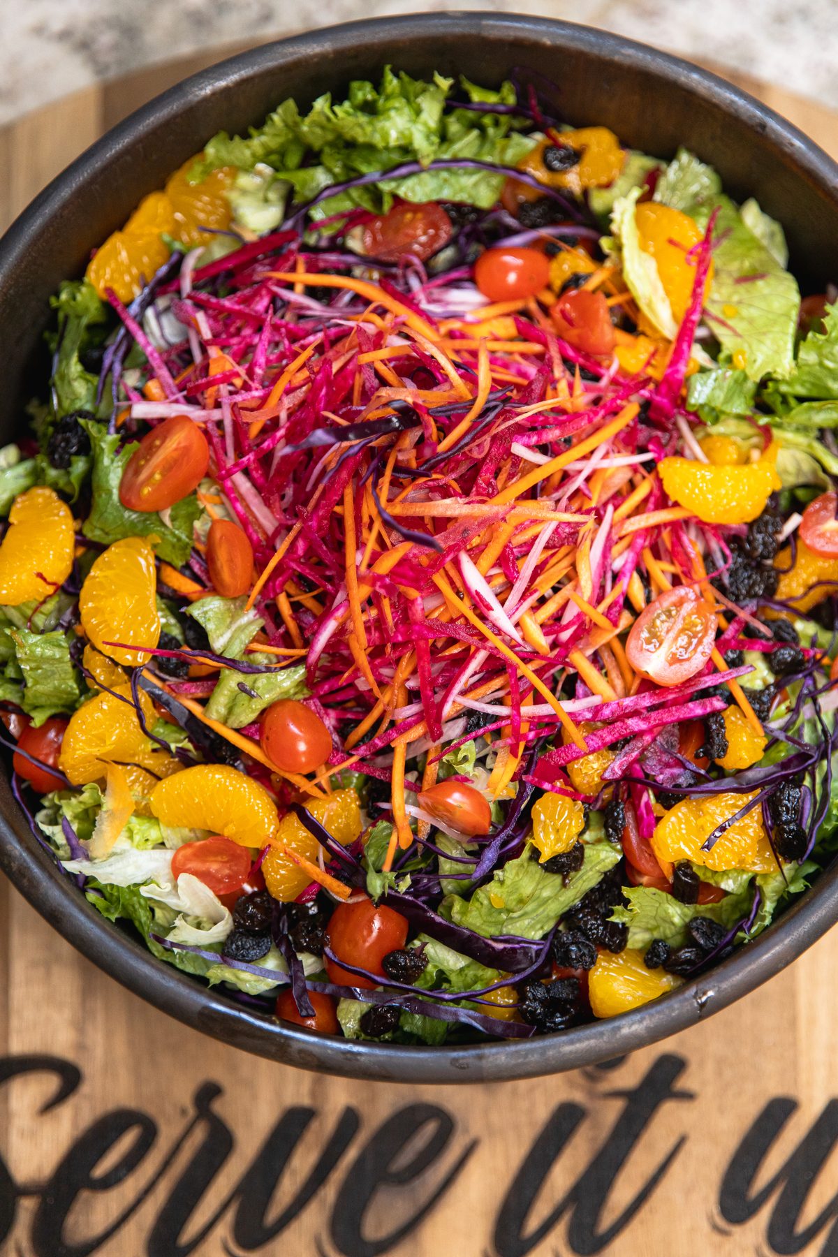 Serve It Up salad plated in a branded wooden bowl