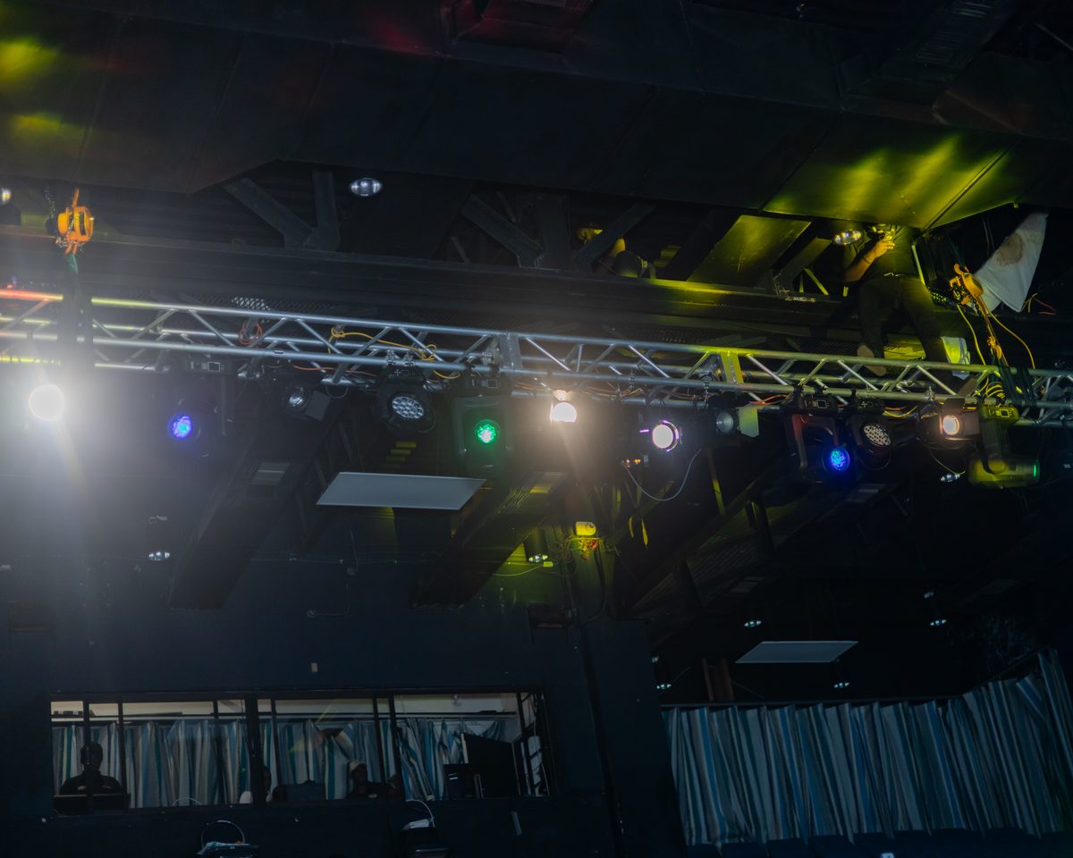 Lighting beams cutting through haze in a dark hall