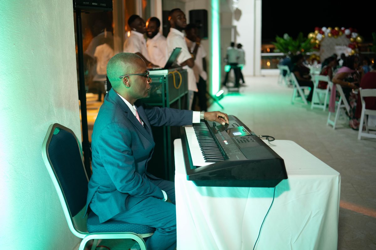 Keyboard player performing under blue stage light