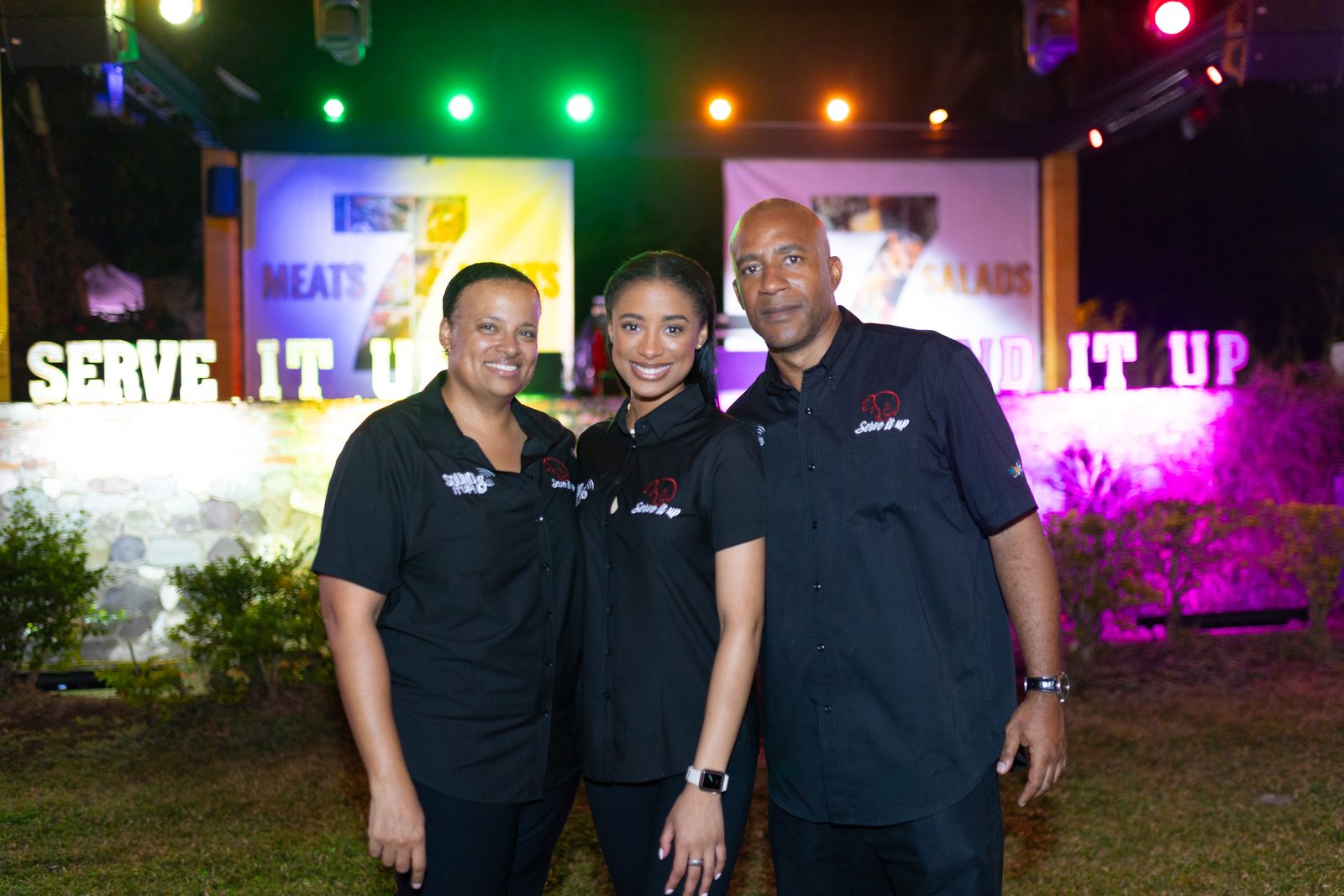 The Sound It Up team in branded shirts in front of a lit stage