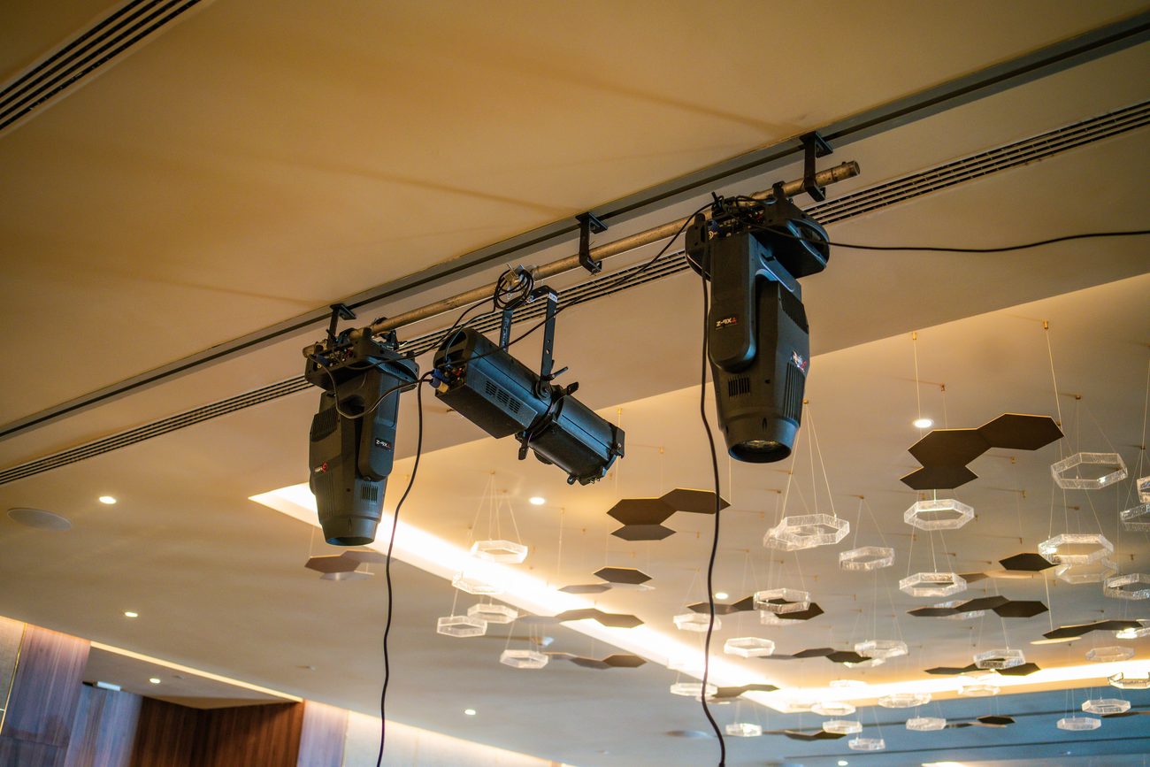 Moving lights hung on truss above the stage