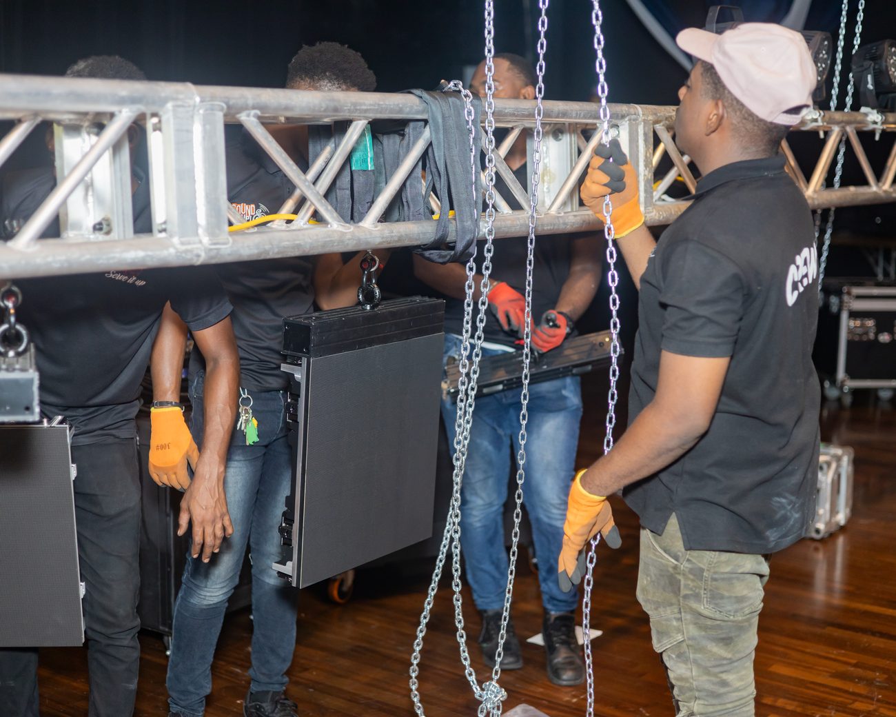 Crew hanging truss with moving lights during load-in