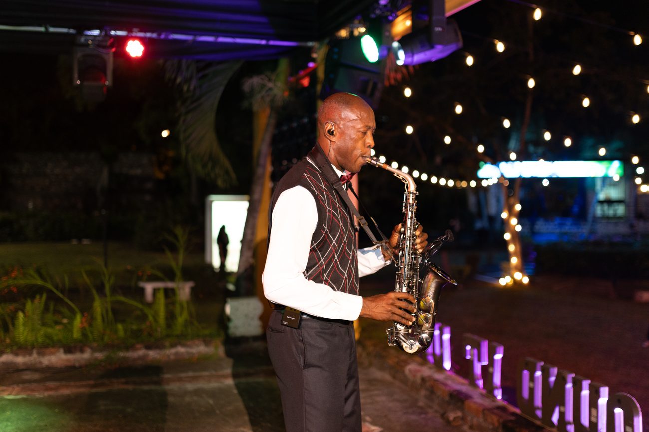 Saxophonist performing under coloured stage uplighting