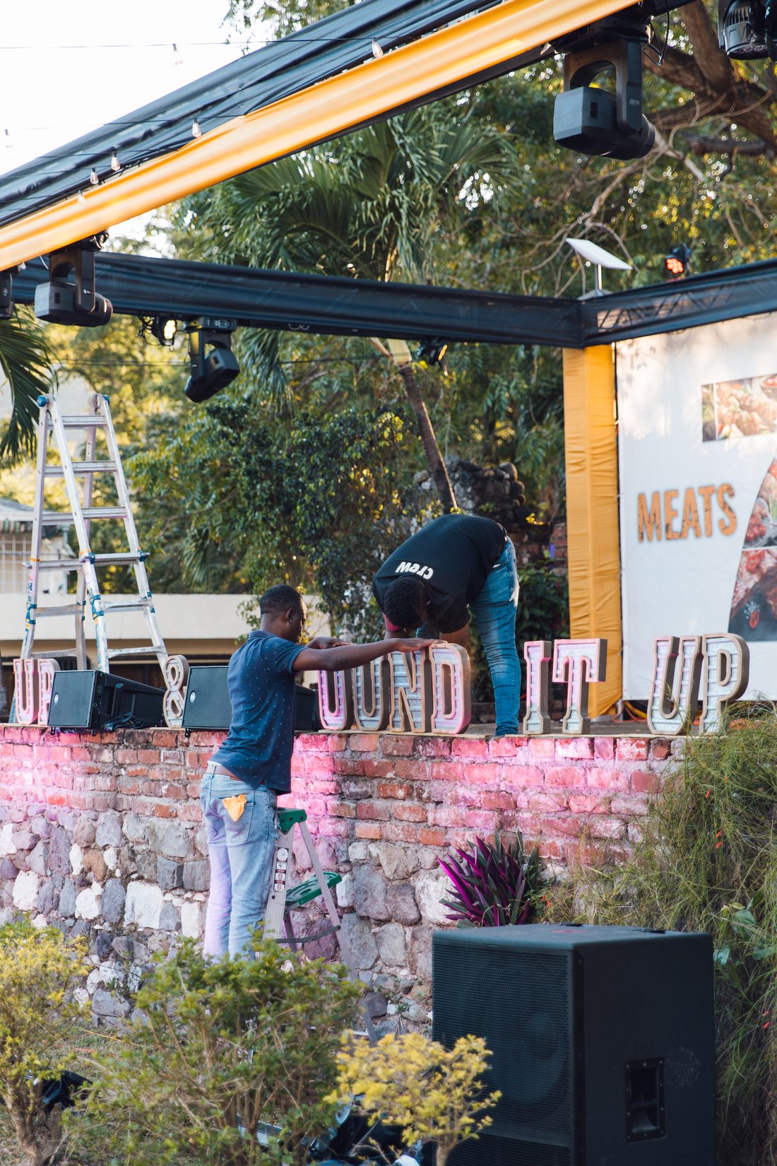 Crew rigging the stage and hanging branding during load-in