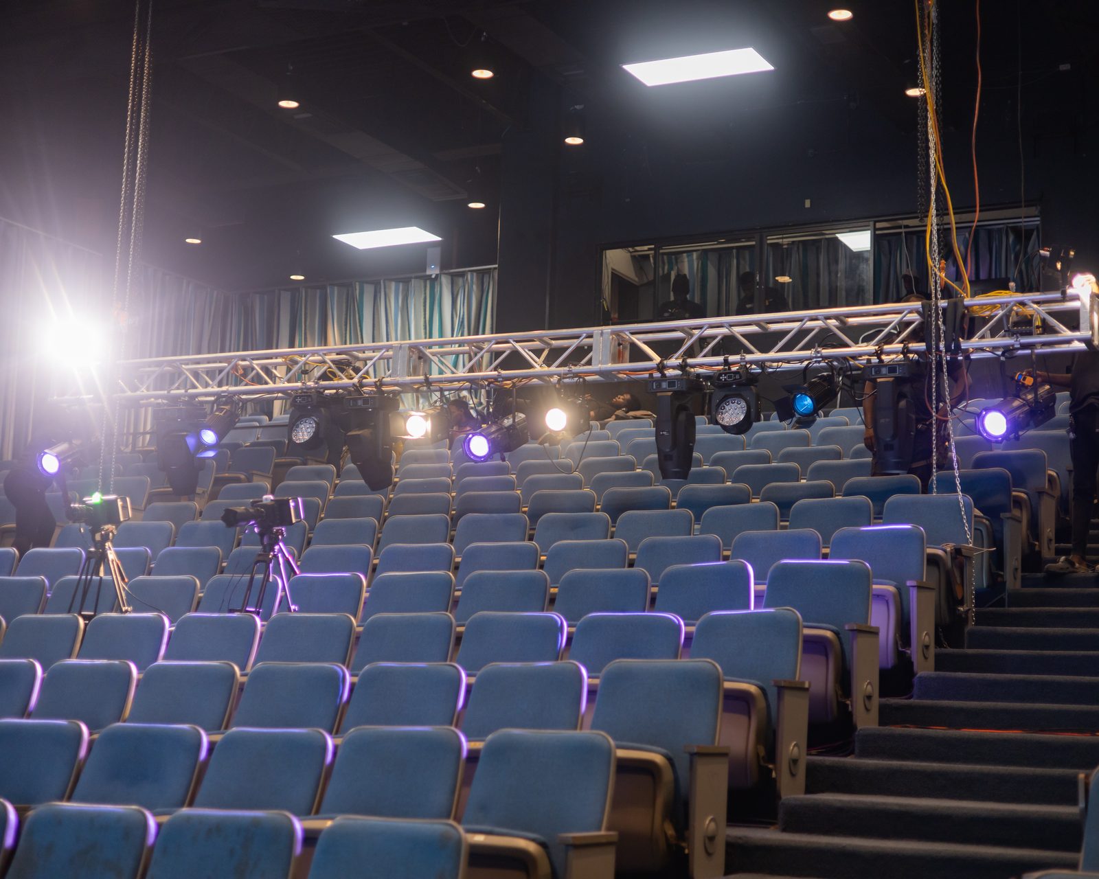 Auditorium with lit truss and moving lights over the seats